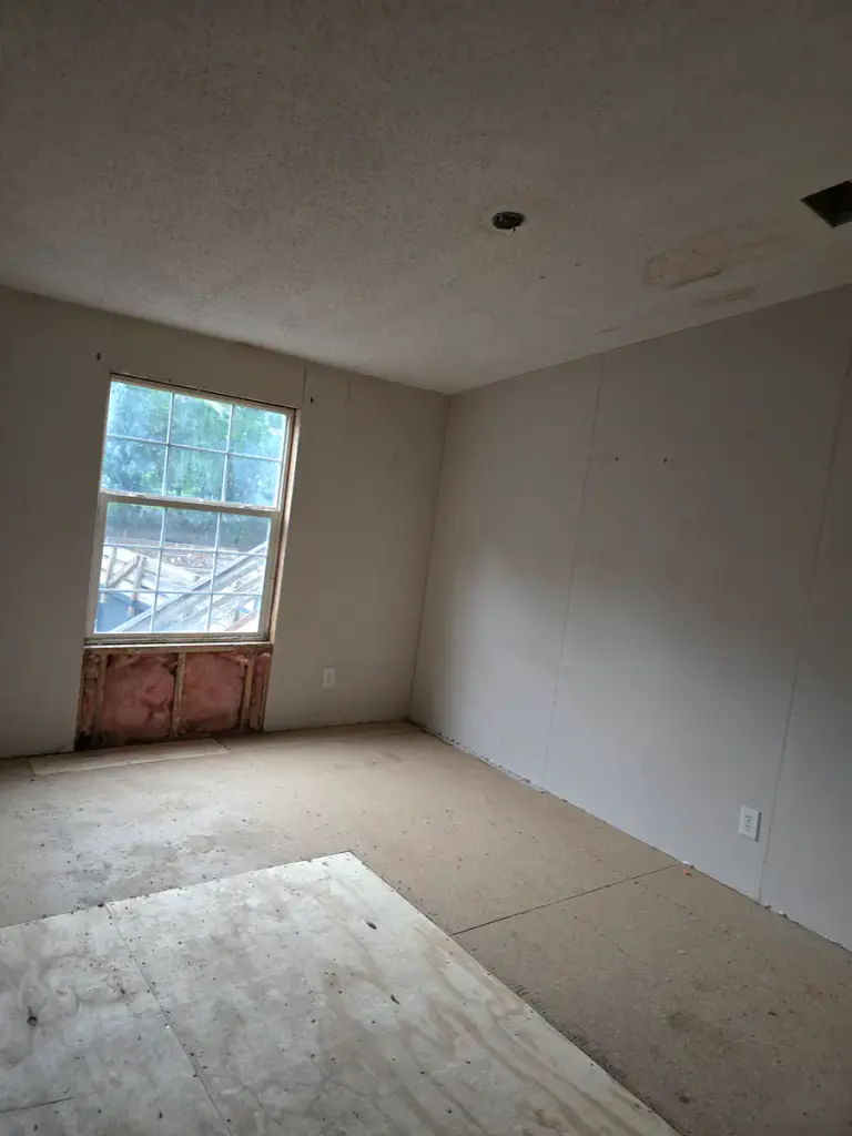 Partially hung drywall beside exposed framing in an interior renovation