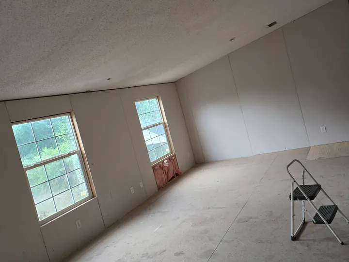 Interior room under renovation with drywall and exposed framing visible