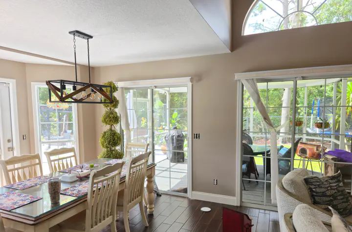 Bright dining area with warm neutral walls, white trim, and outlet plates removed during painting