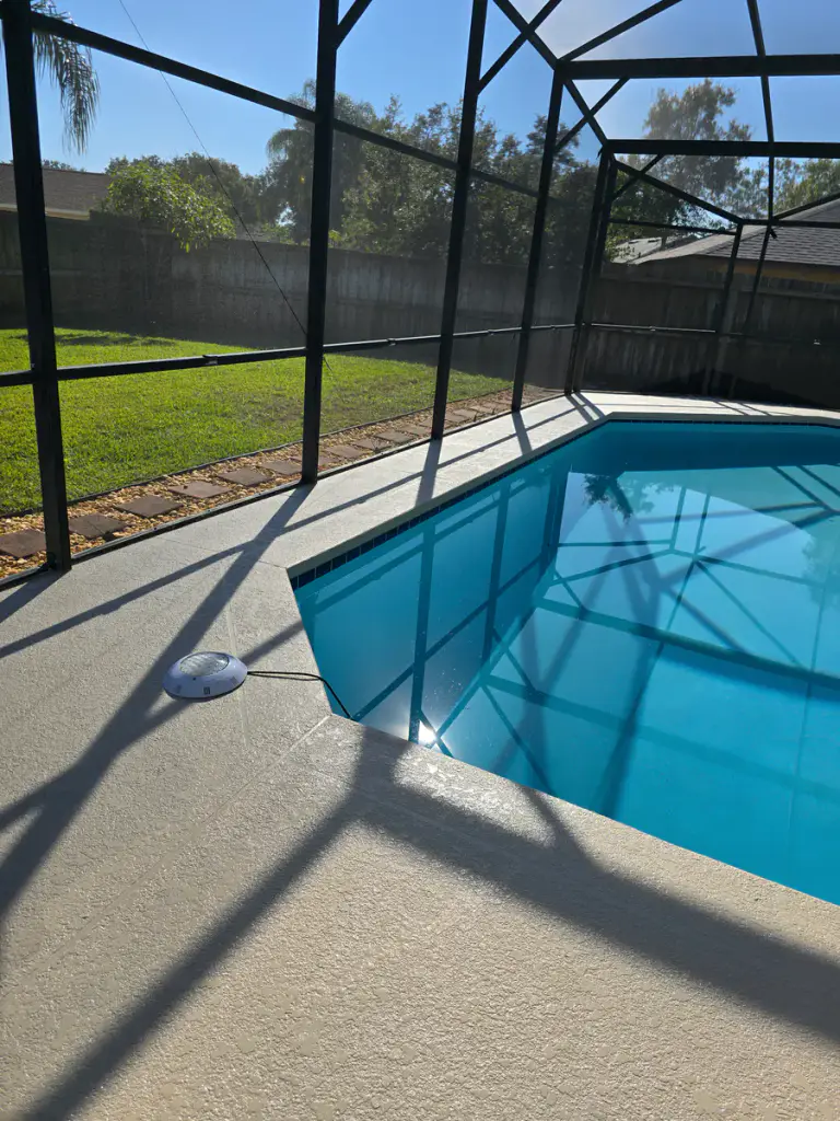Elevated completed view of the coated deck surrounding a screened residential pool.